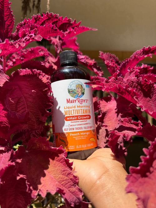 Bottle of Mary Ruth's Multivitamin for Kids amidst pink leafy plants